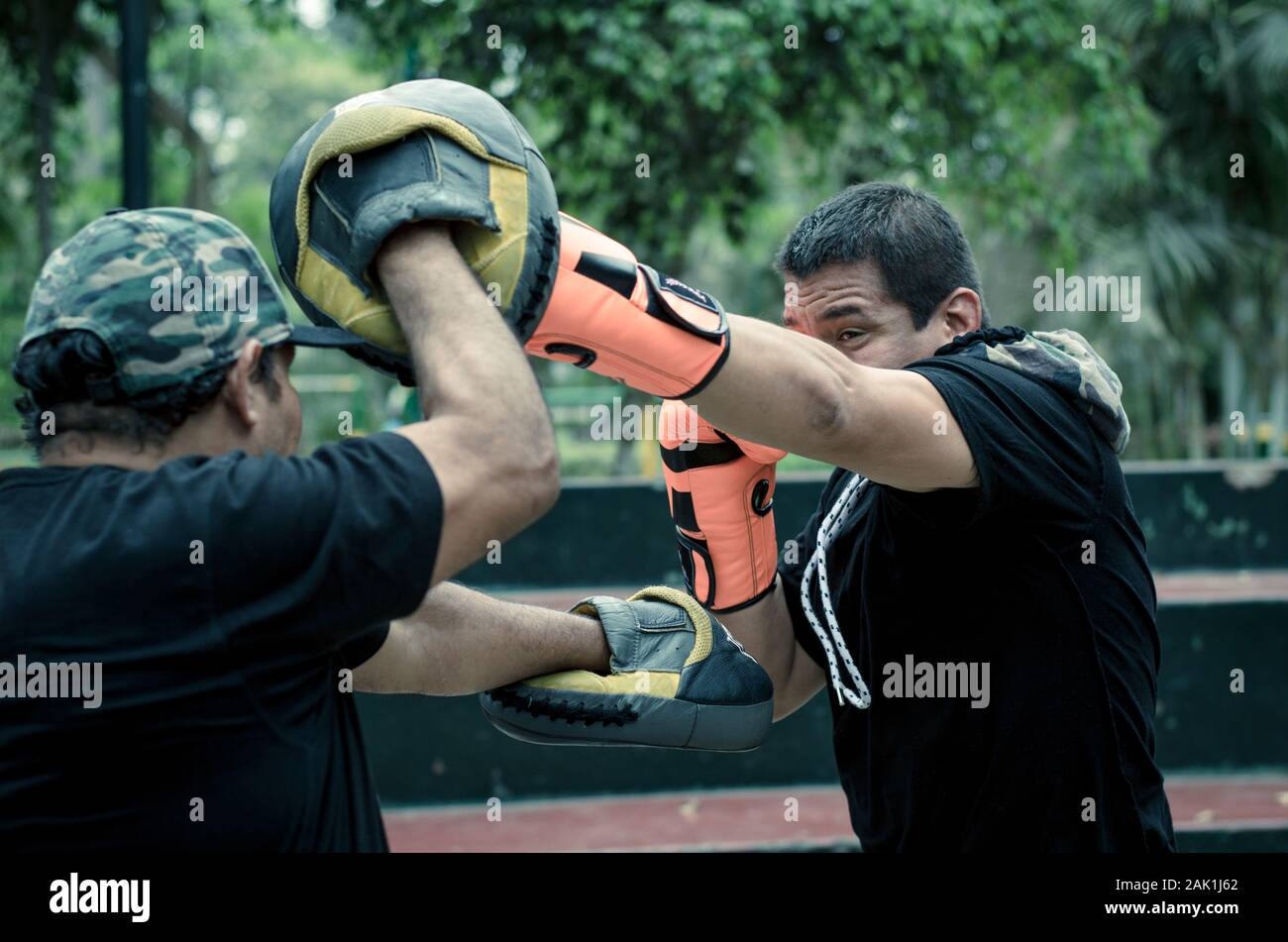 Boxing outdoor Training mit Trainer, schlagtraining mit persönlichem Trainer Stockfoto