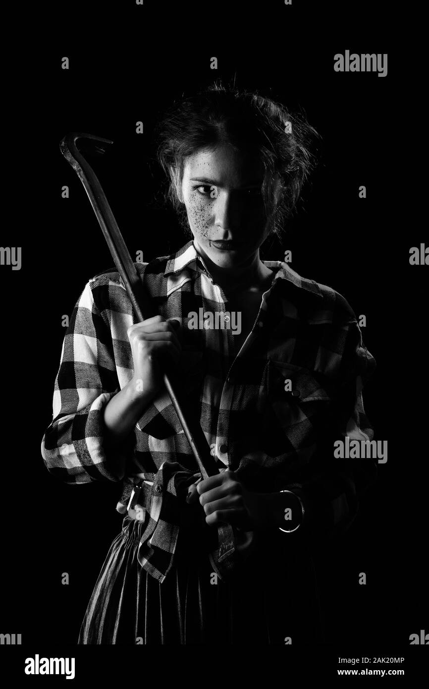 Blutiger ernst junge Frau mit Brecheisen in dunklen Blick auf Kamera monochromen Bild Stockfoto