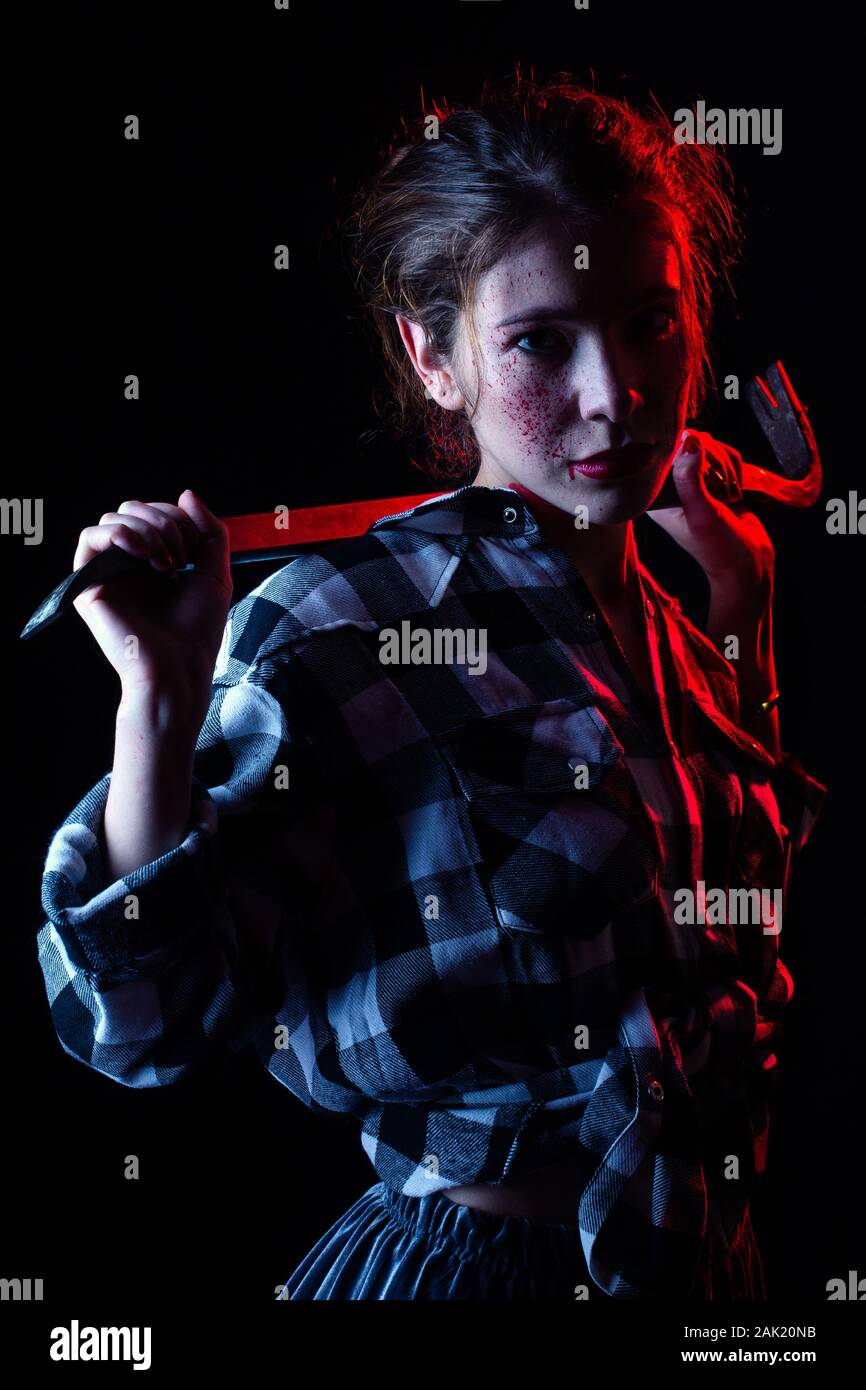 Blutiger ernst junge Frau mit Brecheisen in dunklen Blick auf Kamera getonten Bild Stockfoto