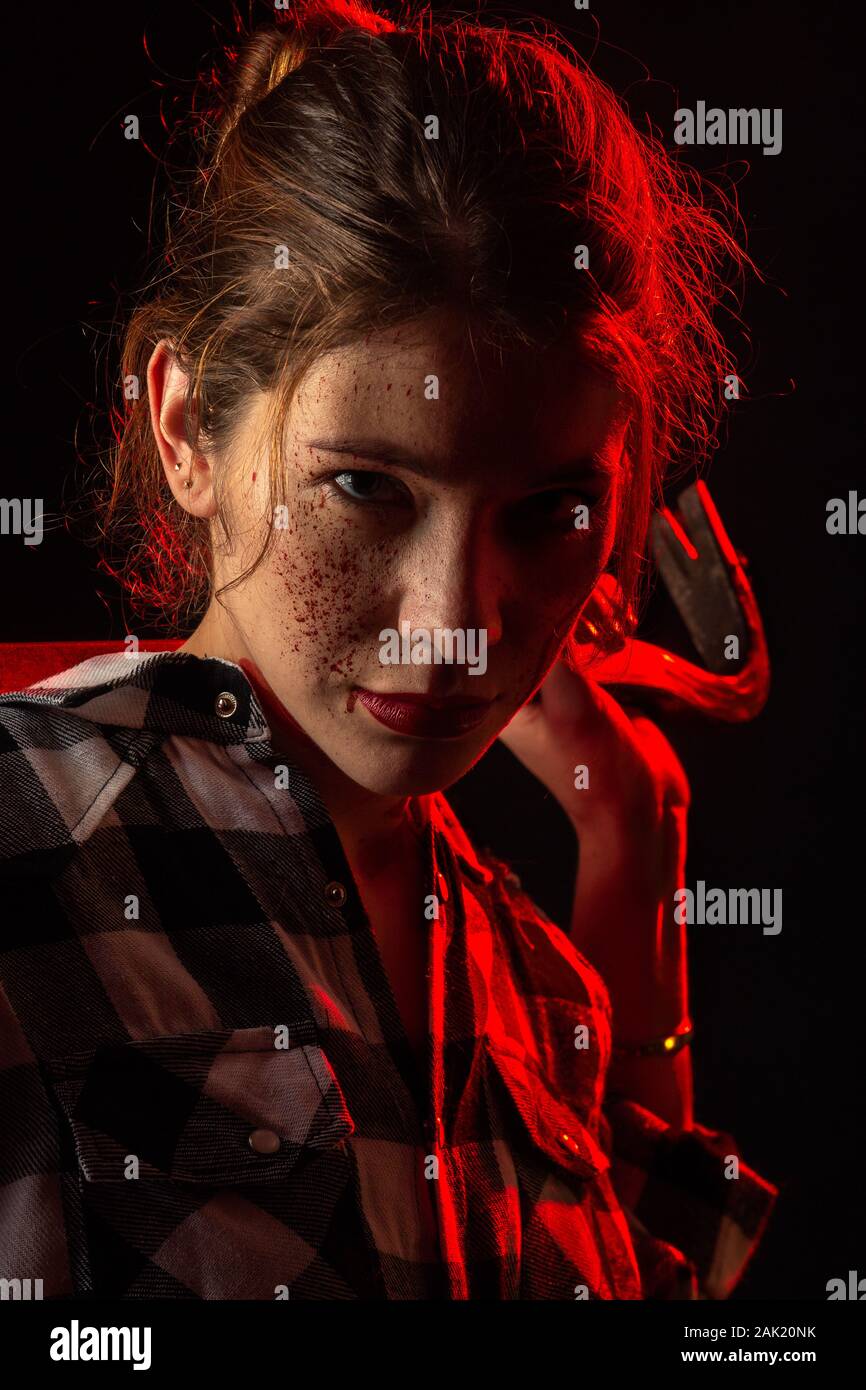 Blutiger ernst junge Frau mit Brecheisen in dunklen Blick auf Kamera getonten Bild Stockfoto