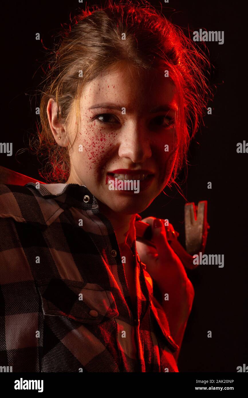 Blutiger ernst junge Frau mit Brecheisen in dunklen Blick auf Kamera getonten Bild Stockfoto
