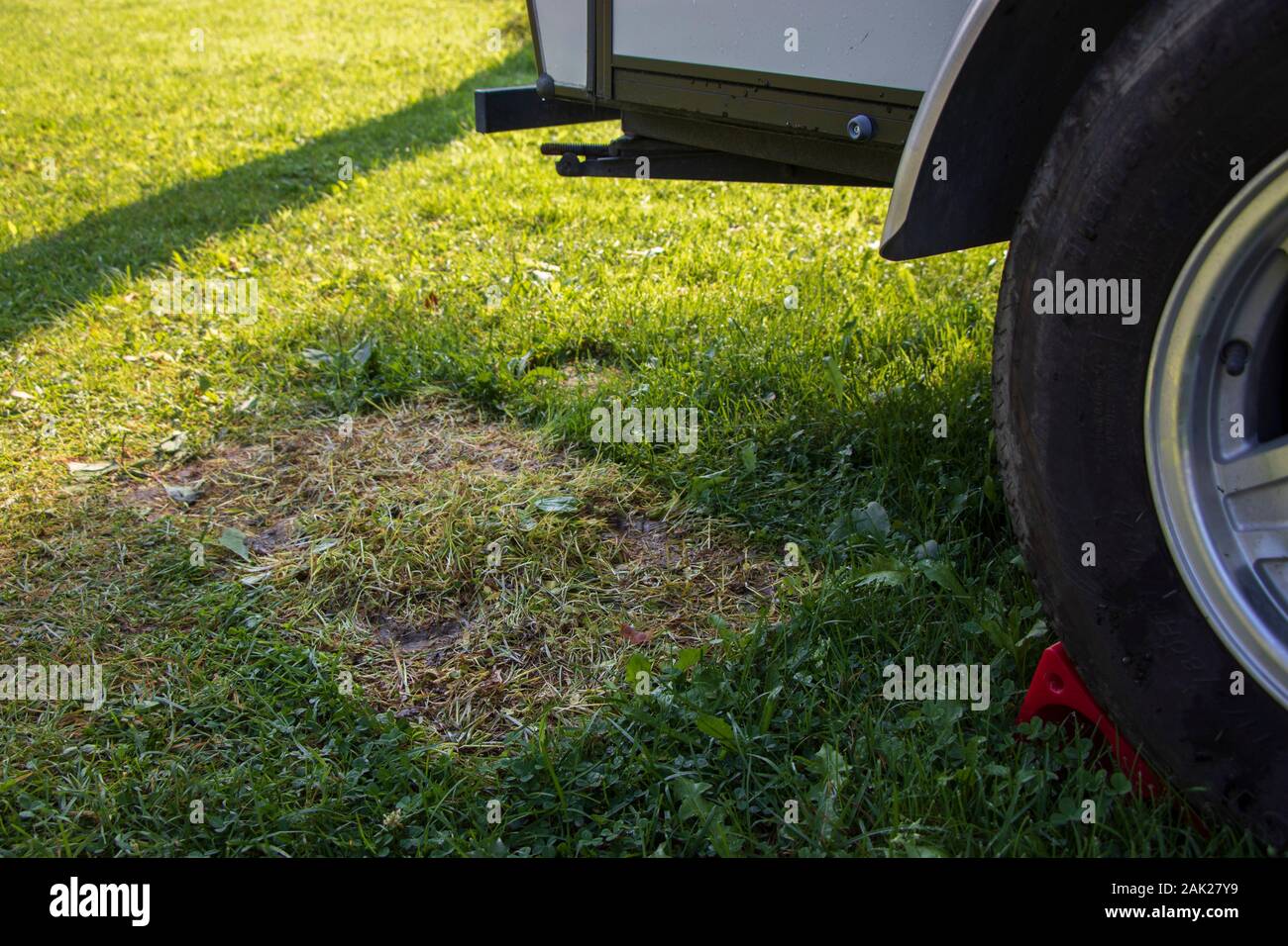 Rasengras durch eine Matte beschädigt und Mangel an Sonnenlicht neben einem Wohnwagen, Wohnmobil Anhänger, Camping, Campingplatz, RV, nachhaltige Praktiken, Leave No Trace Stockfoto