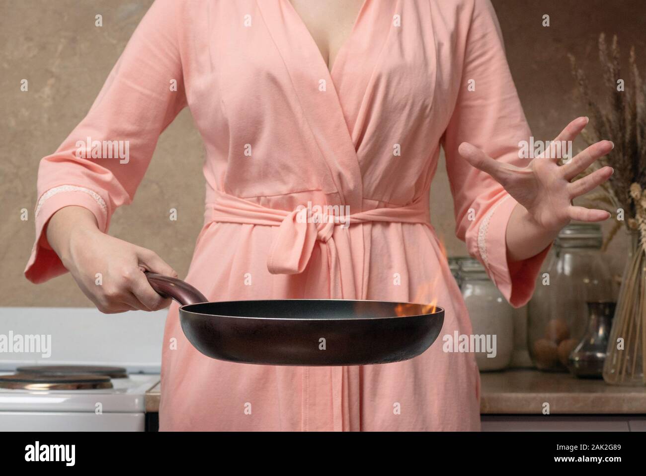 Verwirrt Frau mit Qual omelette Pfanne hautnah. Stockfoto