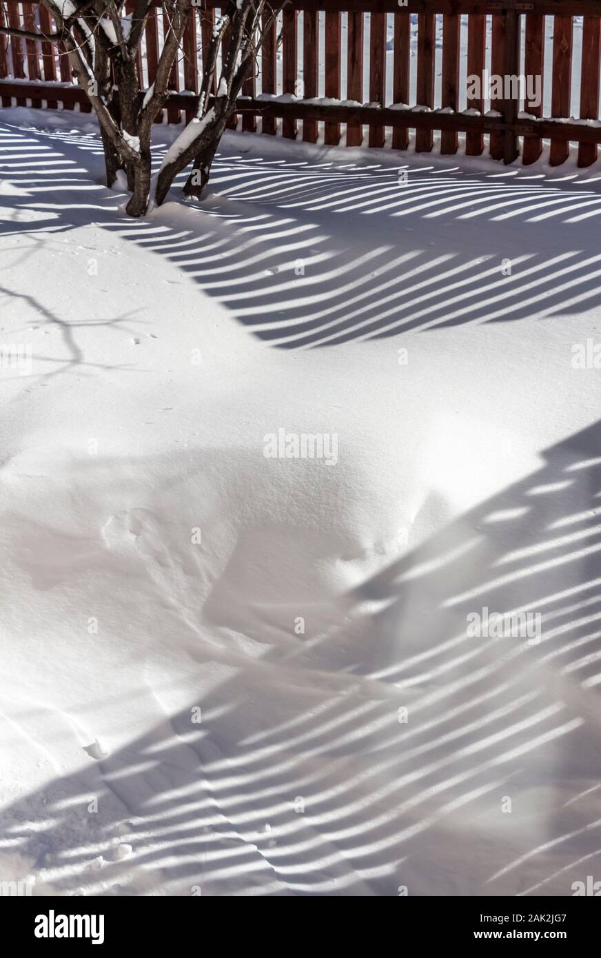 Ländliche Holzzaun bedeckt mit frisch gefallenen Schnee. Stockfoto