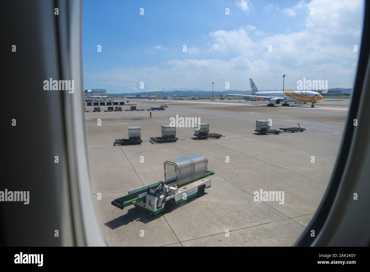 Arbeitswagen und Cargo View Vom Flugzeugfenster - Taoyuan International Airport - Taipeh, Taiwan Stockfoto