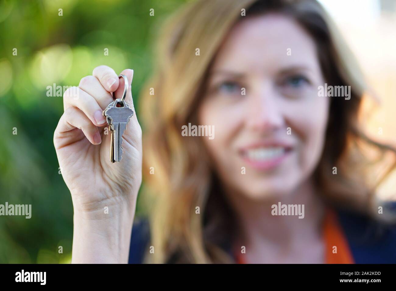Real Estate Agent Frau Lächelt Mit Schlüsseln in der Hand Stockfoto