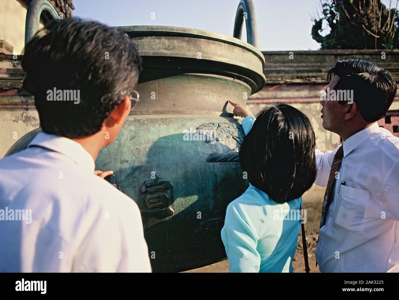 Besucher in Bezug auf eine der dynastischen Urnen vor der Grabstätte von Hien Lam Cac in Hue, einer reichen Geschichte Hafenstadt am Südchinesischen Meer in Ce Stockfoto