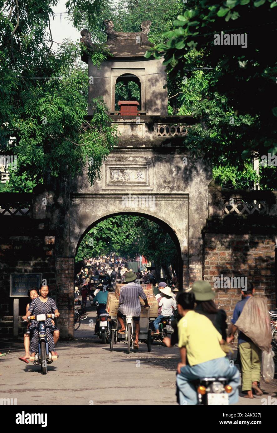 Radfahrer vorbei am Tor zur Altstadt in der Straße Hang Chieu in Hanoi, das ist die Hauptstadt von Vietnam und liegt im Norden von der Südseite Stockfoto