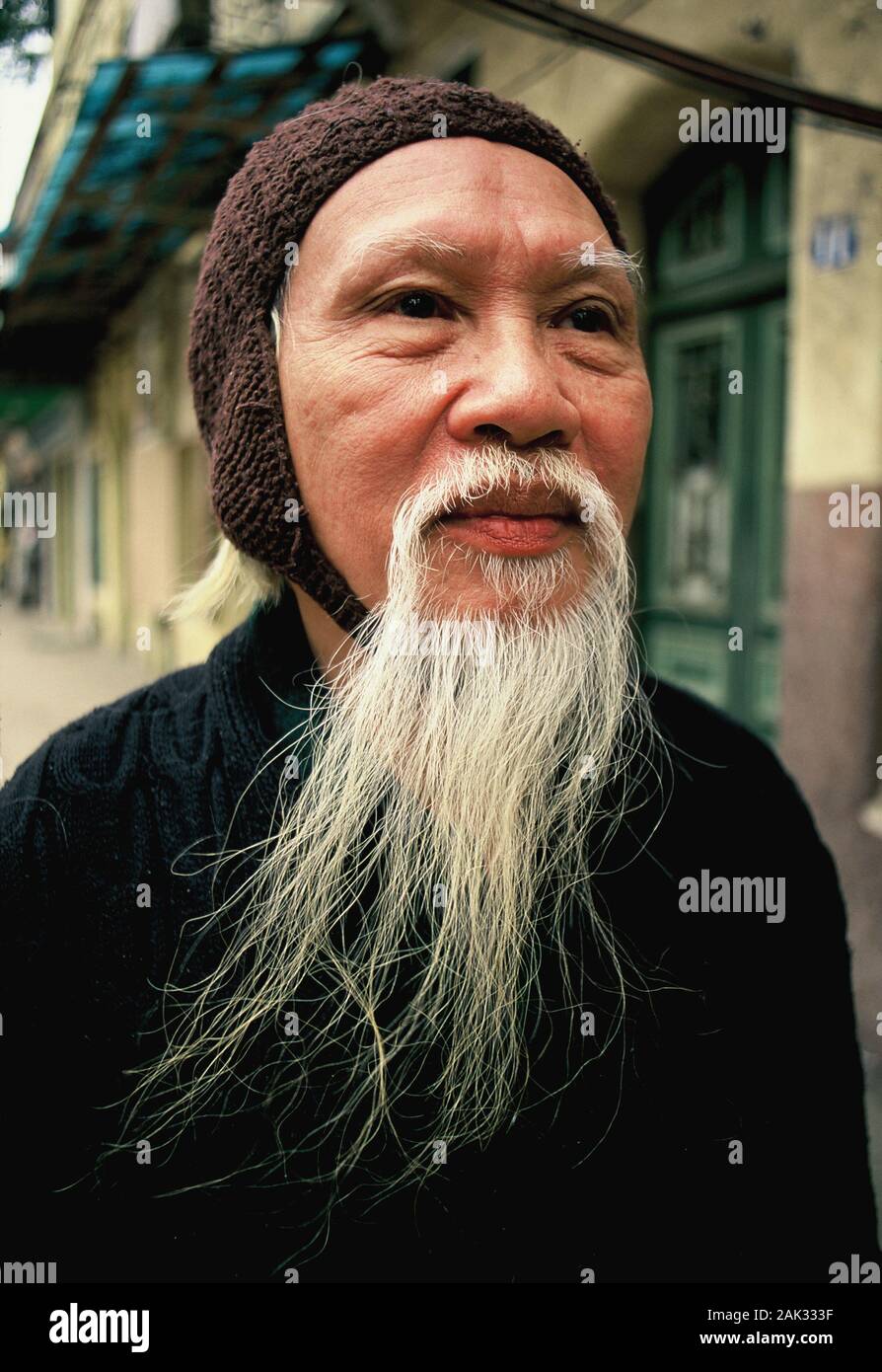 Eine alte Vietnamesische mit einem langen Bart zu Fuß durch eine Straße in Hanoi, das ist die Hauptstadt von Vietnam und liegt im Norden von der südöstlichen Asi entfernt Stockfoto