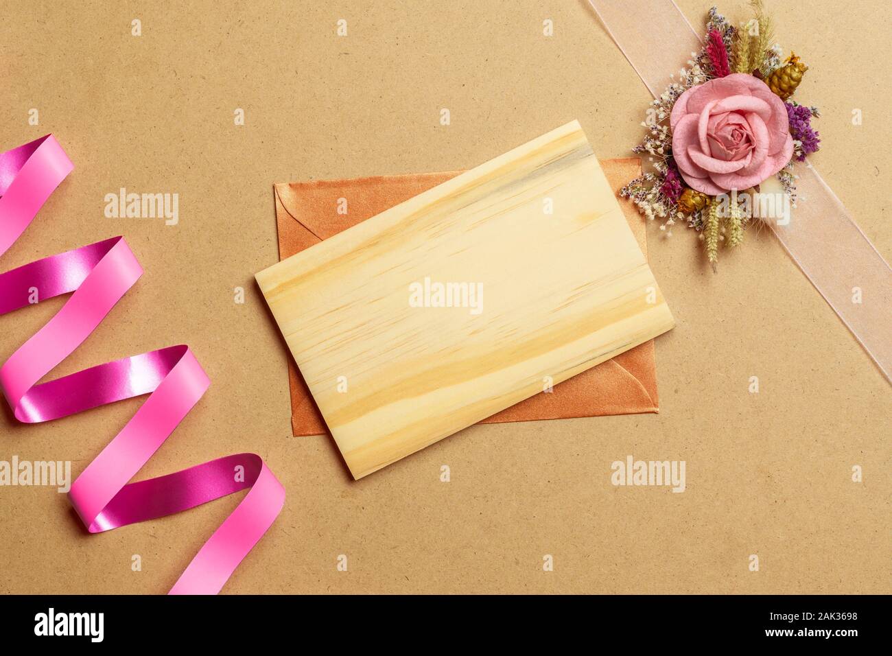 Mockup leer Holz- Karte und Umschlag auf braun Handwerk Papier mit Kraftpapier Rosen zum Valentinstag. Mock up für elegantes Design. Flach Draufsicht va Stockfoto