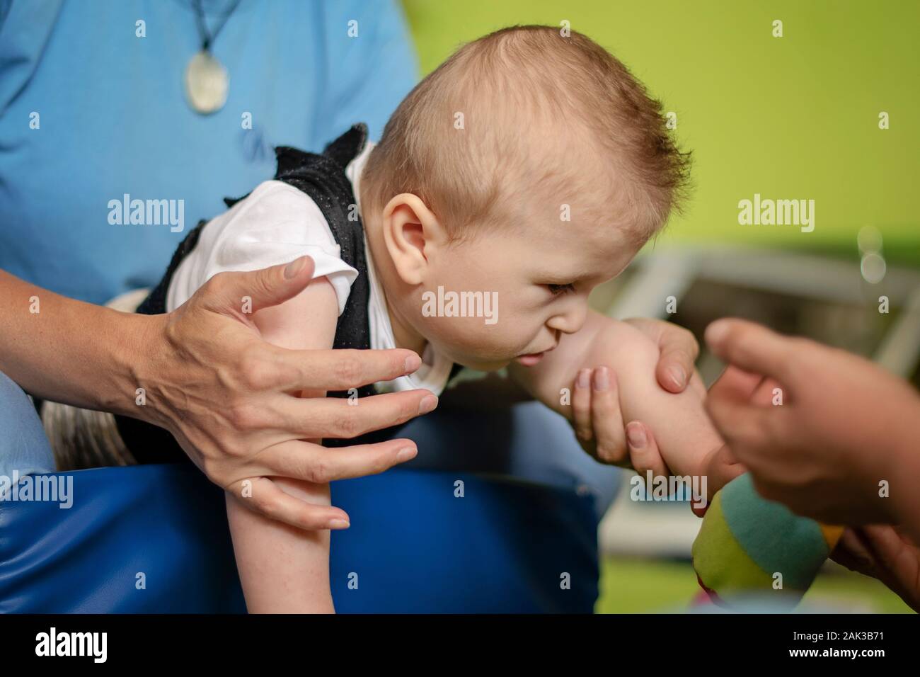 Porträt eines Babys mit zerebraler Lähmung auf Physiotherapie bei Kindern Therapie Zentrum. Jungen mit Behinderung hat die Therapie durch Übungen. Besondere Bedürfnisse. Stockfoto