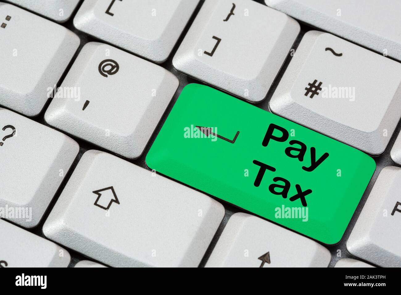 Eine Tastatur mit Pay Tax, die in schwarzer Schrift auf einer grünen ENTER-Taste geschrieben ist. Selbsteinschätzungskonzept für die Zahlung von Steuern. England, Großbritannien, Großbritannien Stockfoto