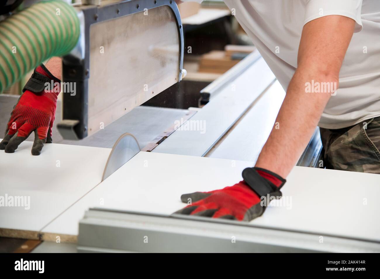 Hände von einem Tischler mit einer Kreissäge in einem Workshop ein holzbrett an der Klinge Stockfoto