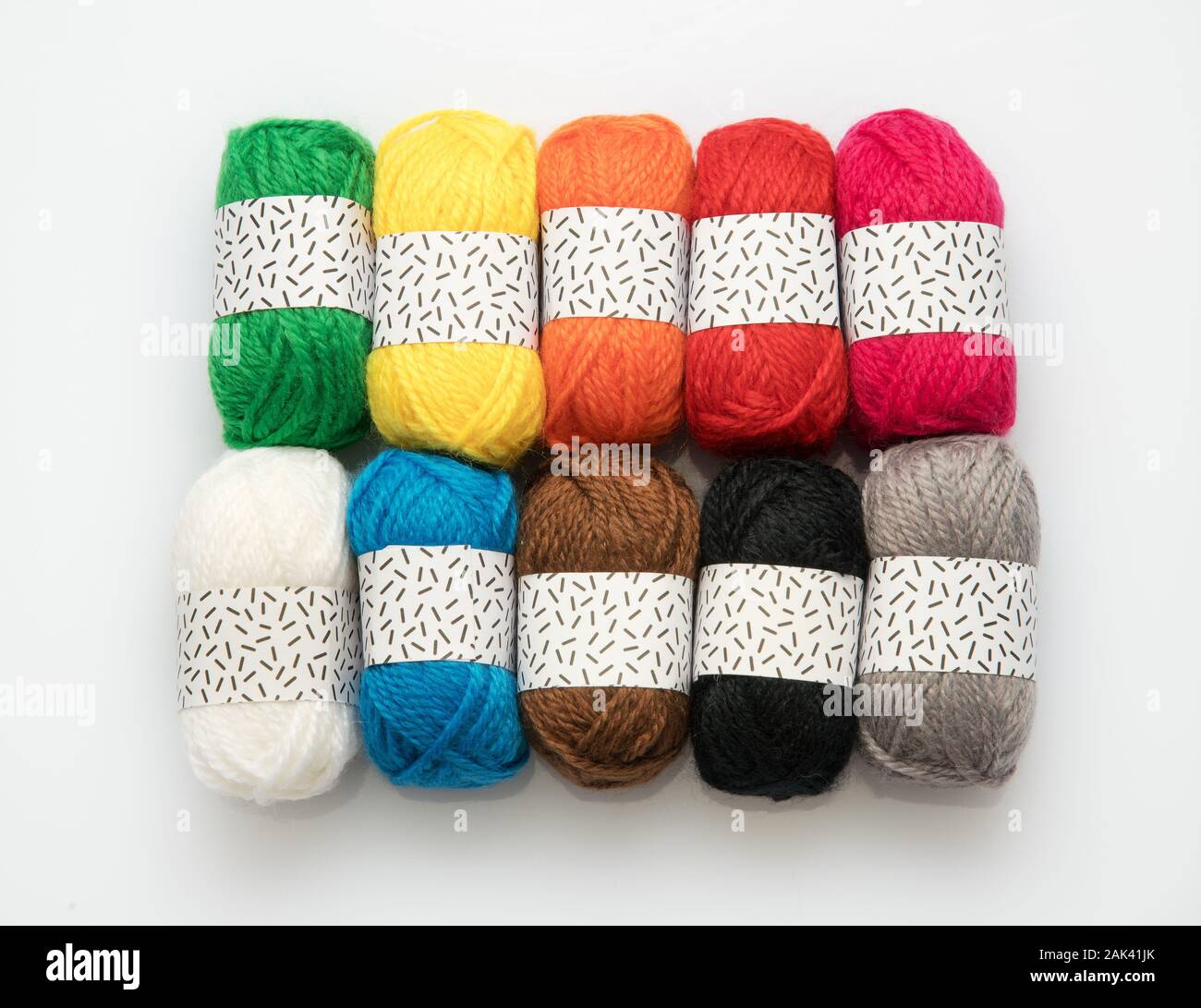Zehn verschiedene Regenbogenfarben der natürlichen gesponnene Wolle Garn in Kugeln für das Stricken und Häkeln auf weißem angezeigt Stockfoto