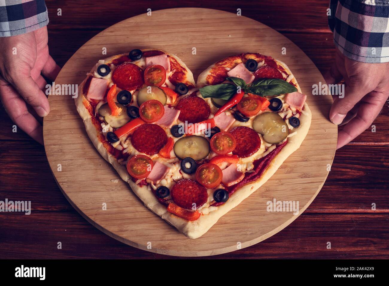 Männliche Hände halten Herzen formen pizza Valentines Tag Überraschung Stockfoto