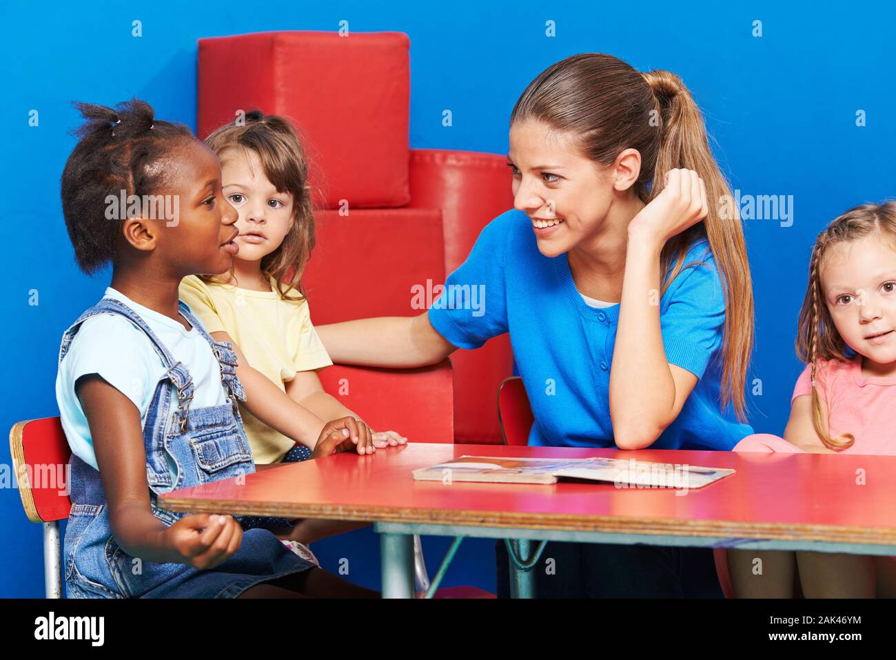 Kinder im Kindergarten Sprachförderung machen im Gespräch mit Erzieher Stockfoto