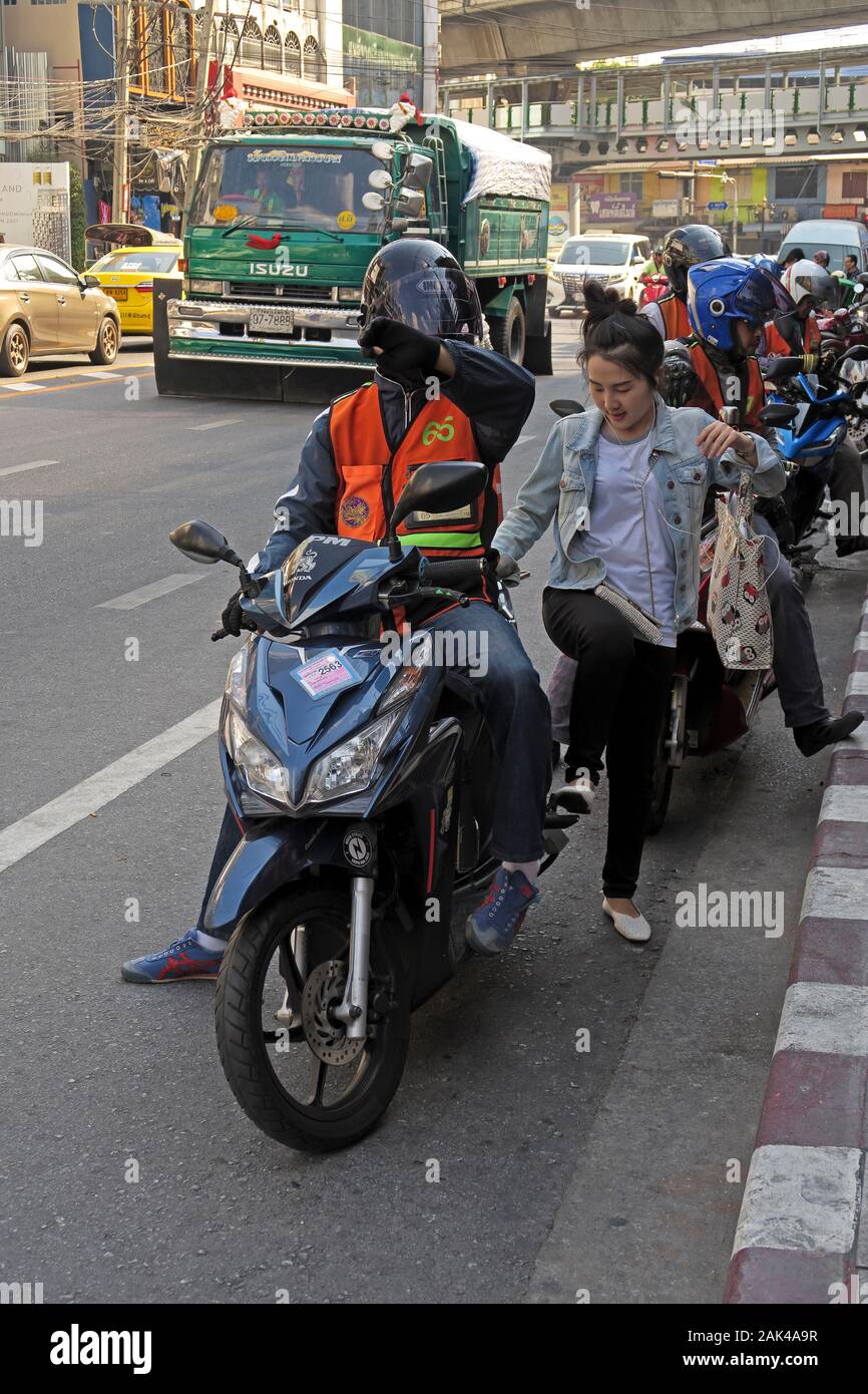 Bangkok, Thailand - 2020.01.04: Motorrad Taxi driver Aufnehmen einer weiblichen Passagier an der Sukhumvit Soi 55 thonglor Stockfoto