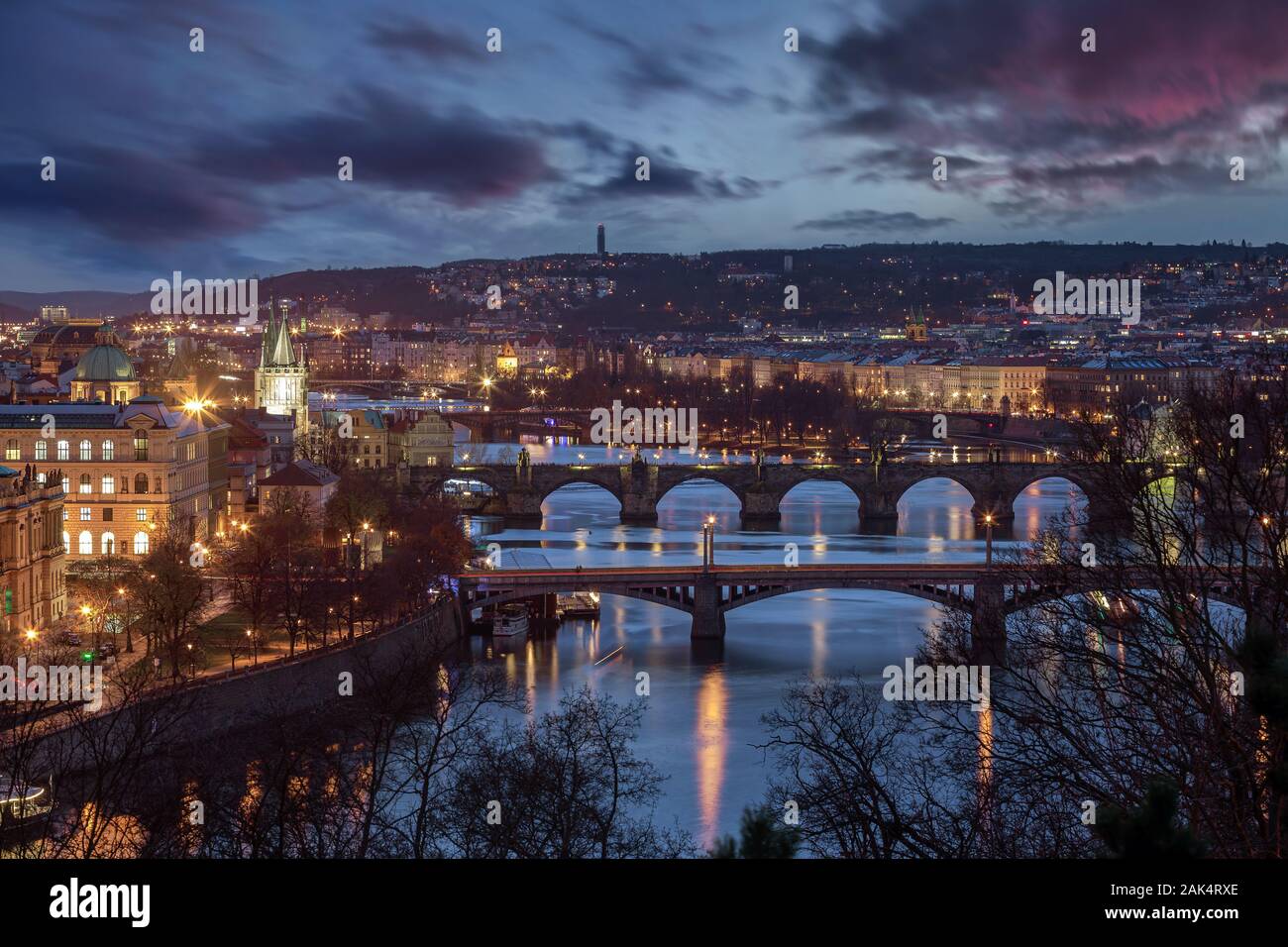 Prag, Tschechische Republik - Panoramablick auf die Skyline der Stadt Prag in der Dämmerung mit lila Wolken. Die beleuchteten Karlsbrücke, St. Franc enthalten Stockfoto