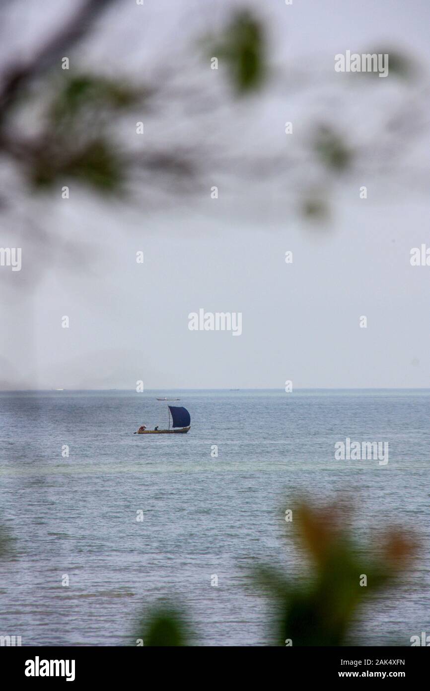 Lokale Fischer, die auf dem Ufer von Conakry, Guinea, Westafrika, in einem einfachen, selbstgefertigten Segelboot fahren Stockfoto