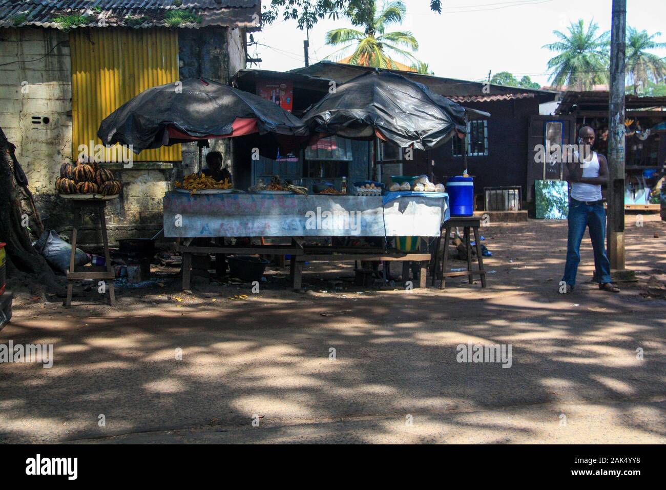 Blick auf einen sehr einfachen Lebensmittelstall neben der Straße in Conakry, Guinea, Westafrika Stockfoto