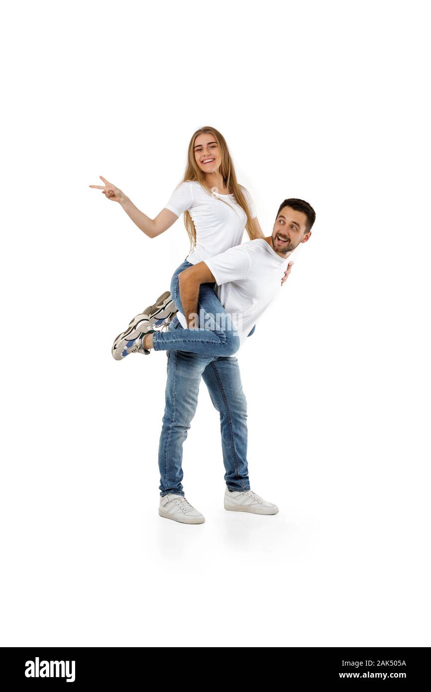 Mann, junge Frau auf seinem Rücken. Freund huckepack mit Freundin auf weißem Hintergrund Stockfoto