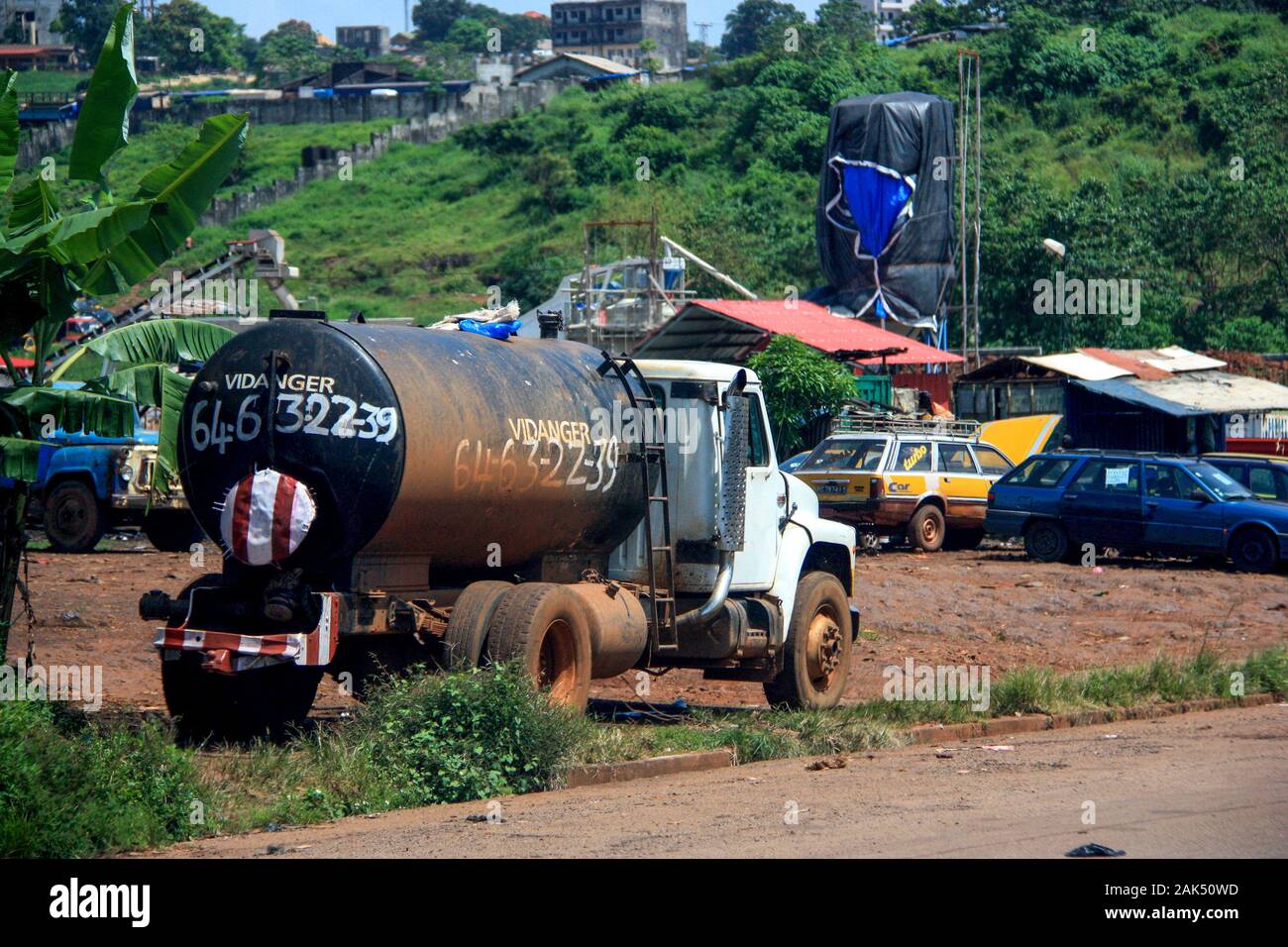 Der alte Lastwagen parkte auf einem typischen Parkplatz neben der Hauptstraße in Conakry, Guinea, Westafrika Stockfoto