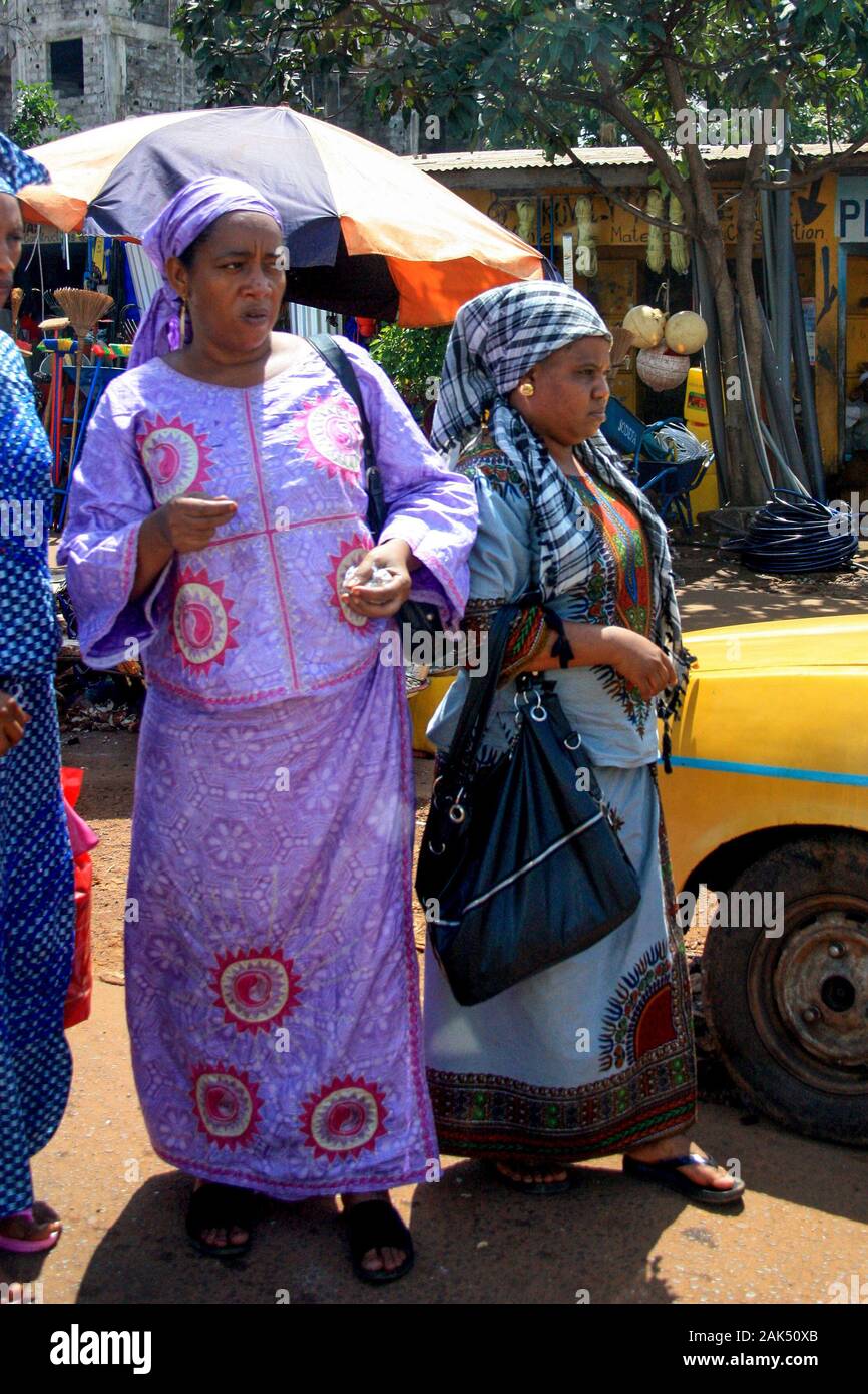 Zwei Seniorinnen in traditioneller und bunter Kleidung auf dem Markt in Conakry, Guinea, Westafrika Stockfoto