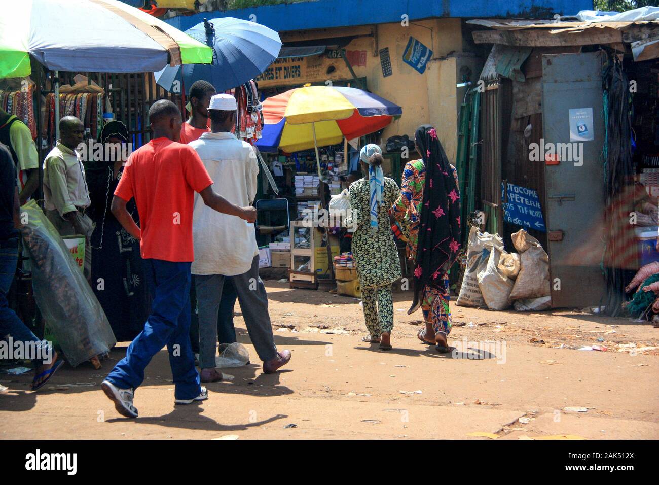 Die Menschen schlendern auf dem Markt in Conakry, Guinea, Westafrika entlang der Feldstraße Stockfoto