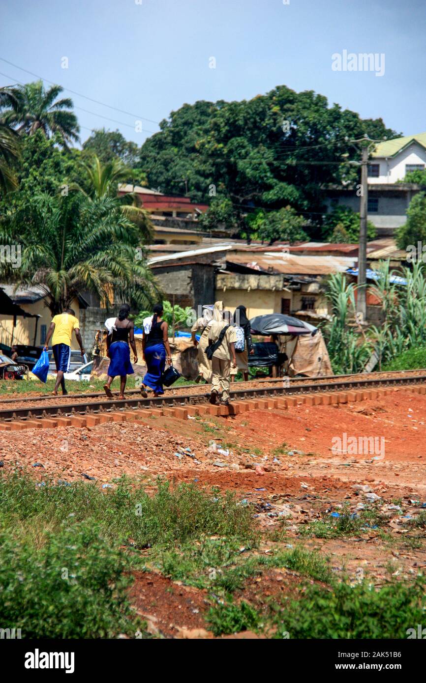 Afrikanische Menschen gehen auf Bahnstrecken in Conakry, Guinea, Westafrika Stockfoto