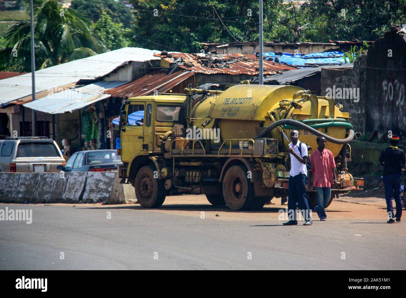 Blick auf einen gelben Kanalisationswagen, der an der Seite einer Straße in Conakry, Guinea, Westafrika geparkt ist Stockfoto
