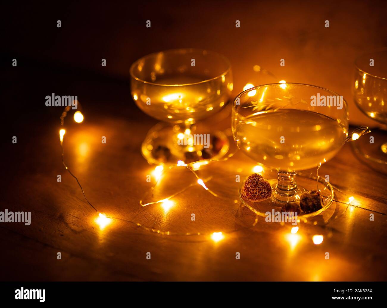Zwei Cocktailgläser mit Beeren und Lichter leuchten auf hölzernen Hintergrund noch Leben Stockfoto