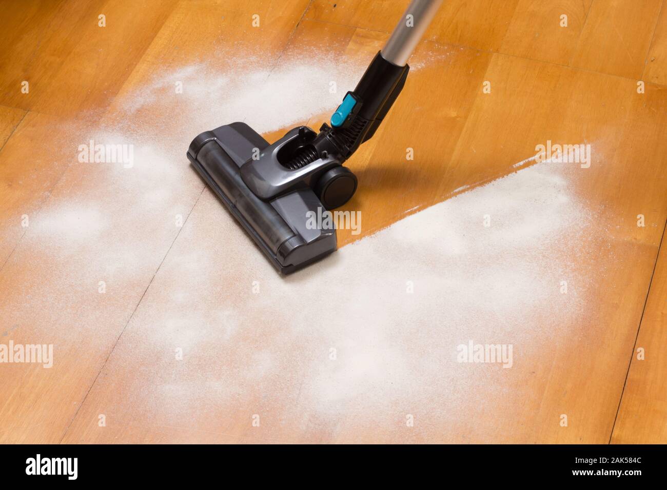 Staubsauger Bürste Reinigung Mehl auf dem Küchenboden Stockfoto