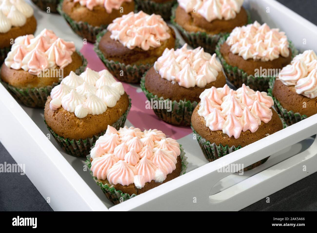Cupcakes mit rosa Creme auf einem weißen Fach. Stockfoto
