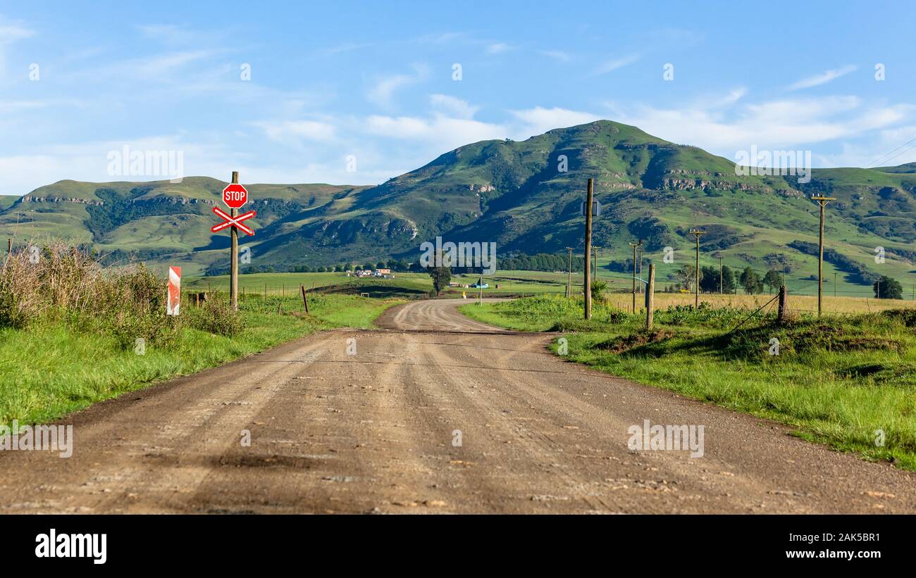Dirt-Road-Stoppschild Zuggleise überqueren ländliche Berge Bauernland Sommerlandschaft Stockfoto