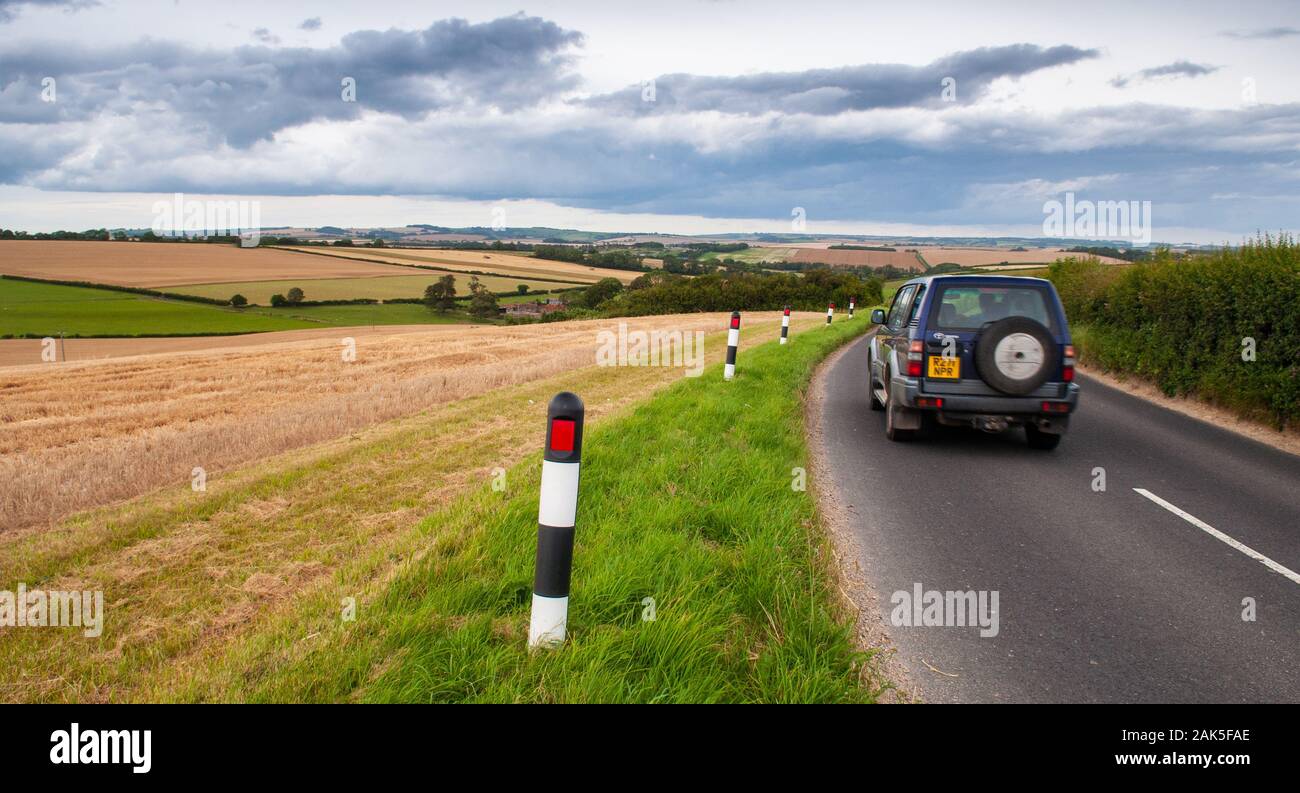 Dorchester, England, UK - 30. Juli 2012: fährt ein Auto entlang einer Landstraße über der Piddle Tal in der pastoralen Landschaft der Dorset Dow Stockfoto