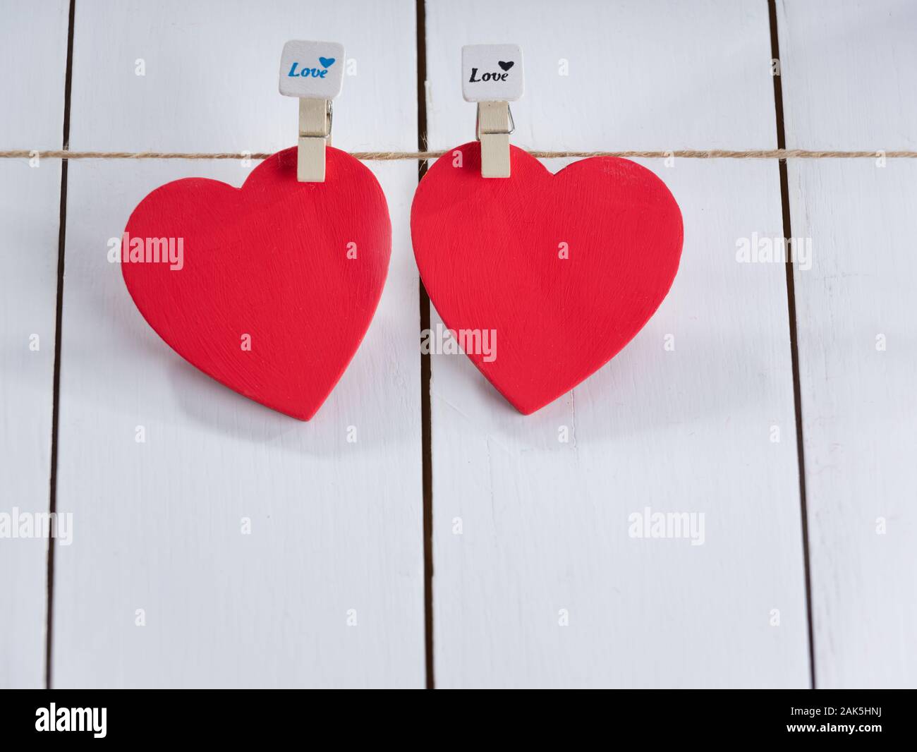 Zwei rote Herzen auf String mit weißem Hintergrund. Valentinstag Konzept. Platz für Text Stockfoto