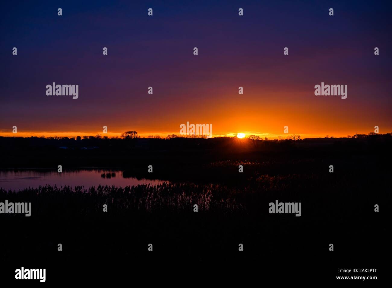 Sonnenuntergang über der Auen und Wäldern, Lunt Wiesen RSPB Nature Reserve, Merseyside Stockfoto