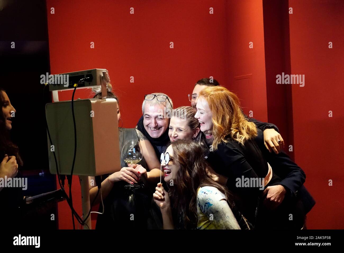 Gruppe von Menschen feiern das Ende der Saison Foto. Die Menschen Lächeln, Lachen, machen lustige Gesichter und Posieren vor der Photobox. Stockfoto