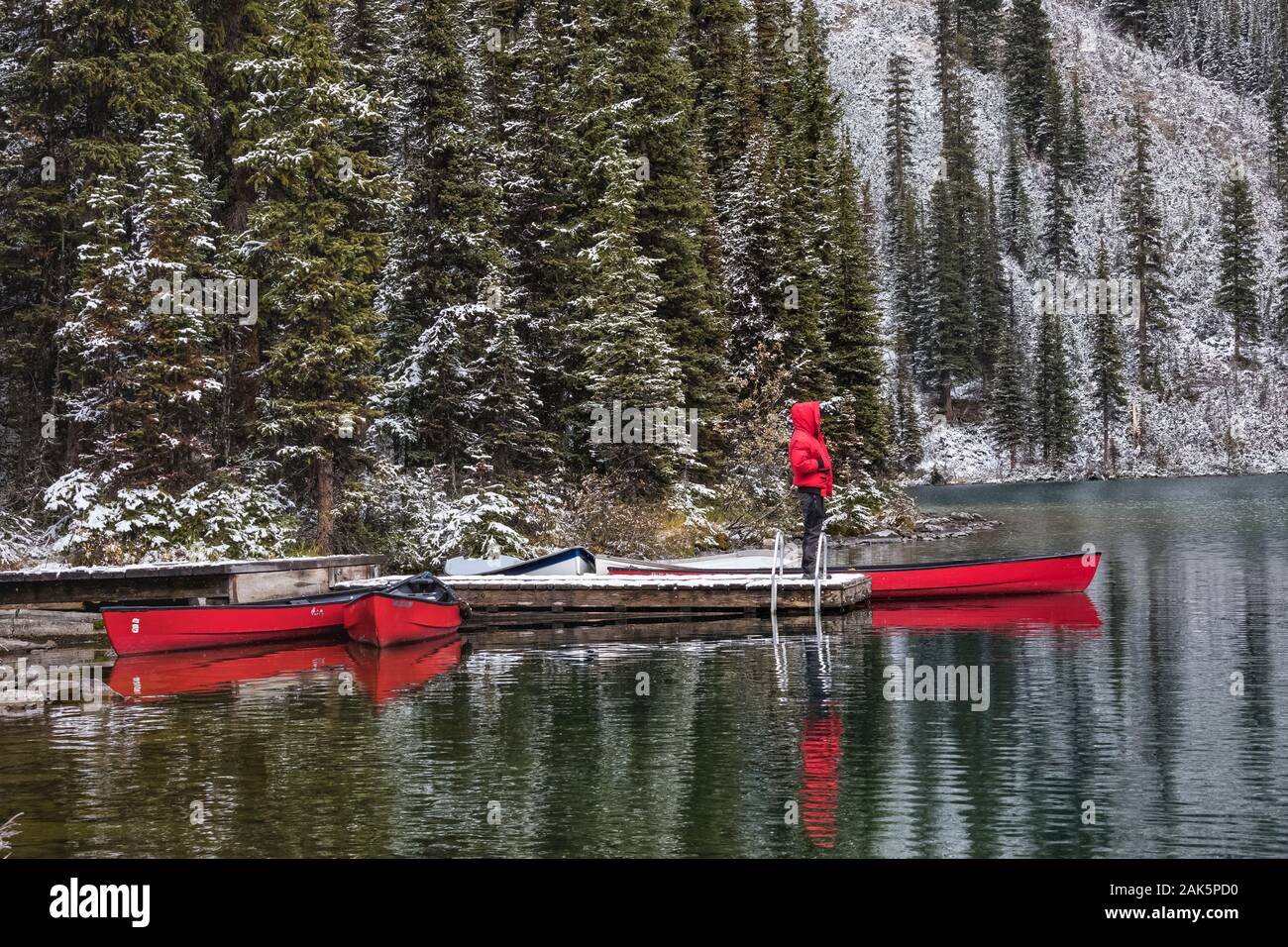 Mann in Rot mit rotem Kanus am Lake O'hara Lodge Dock im September im Yoho National Park, British Columbia, Kanada [kein Modell Release; für Edi verfügbar Stockfoto