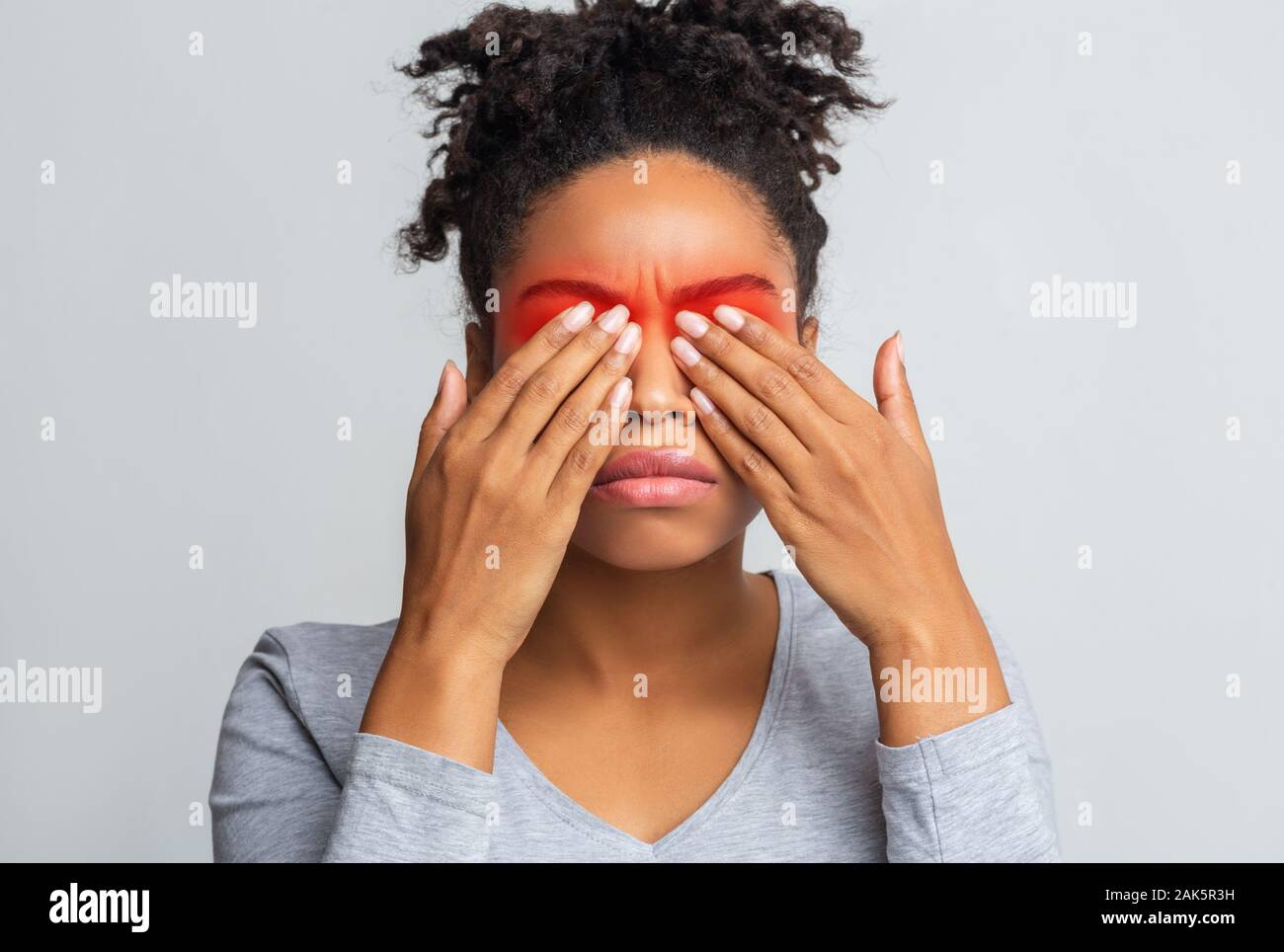 Schwarze Frau, die ihre Augen mit Palmen, Red Zone hervorgehoben, Augenkrankheiten Konzept Stockfoto