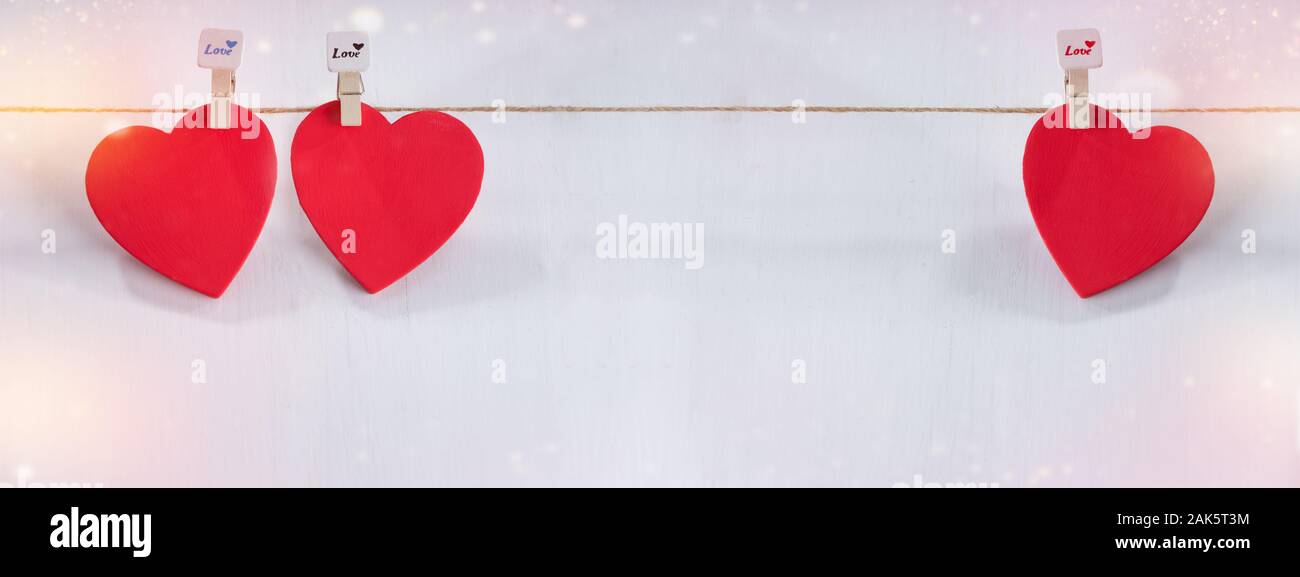 Drei rote Herzen auf String mit weißem Hintergrund. Valentinstag Konzept. Platz für Text Stockfoto