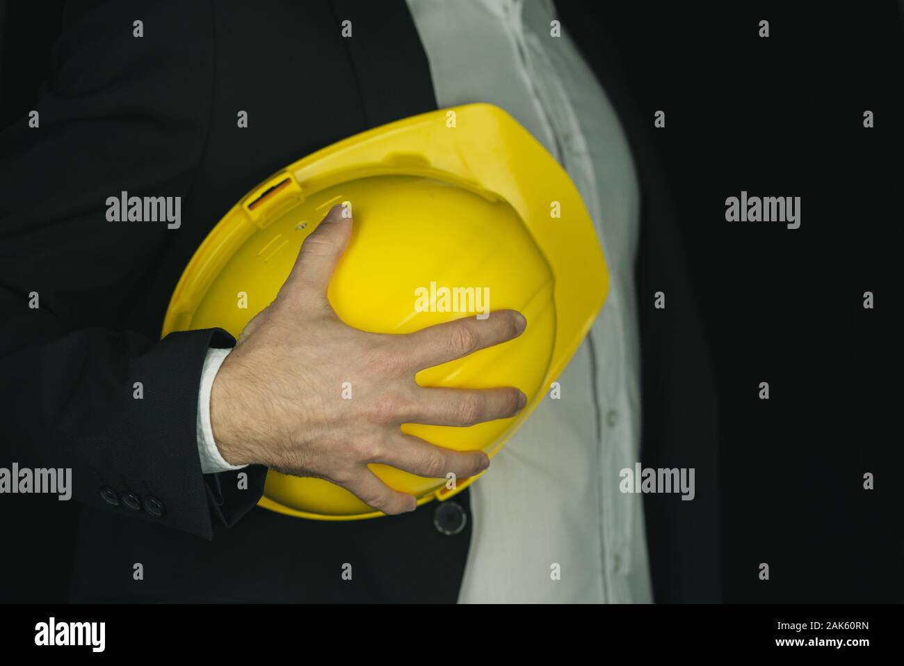 Detailansicht des Auftragnehmers in einem Anzug mit leuchtend gelben Arbeitsschutzausrüstungen Helm. Stockfoto