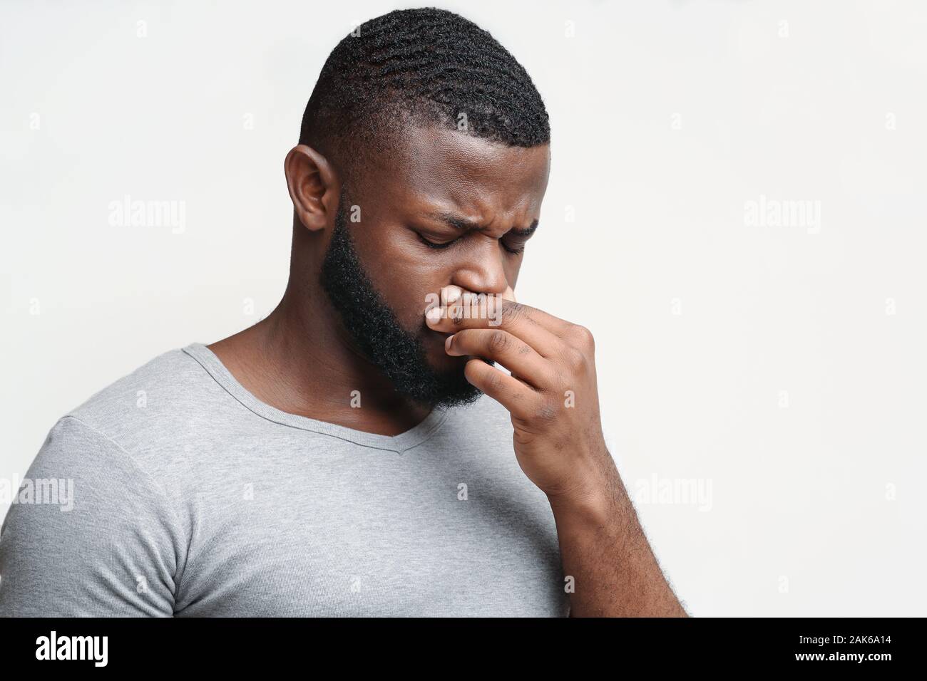 Afro Kerl, der seine Nase berühren, laufende Nase, von saisonale Allergien leiden, kopieren Raum Stockfoto