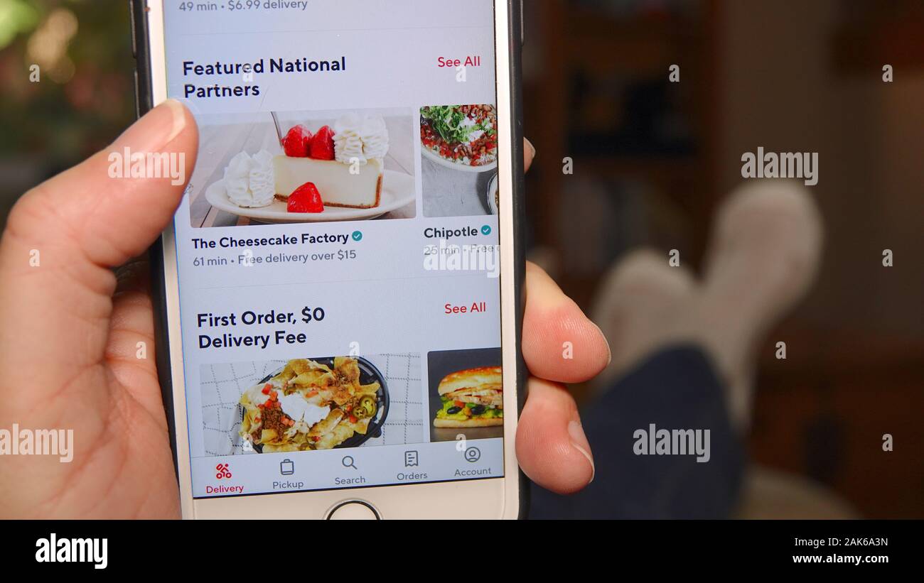 Person zu Hause, mit DoorDash app Essen zu bestellen. Der Bildschirm "Telefon". Stockfoto