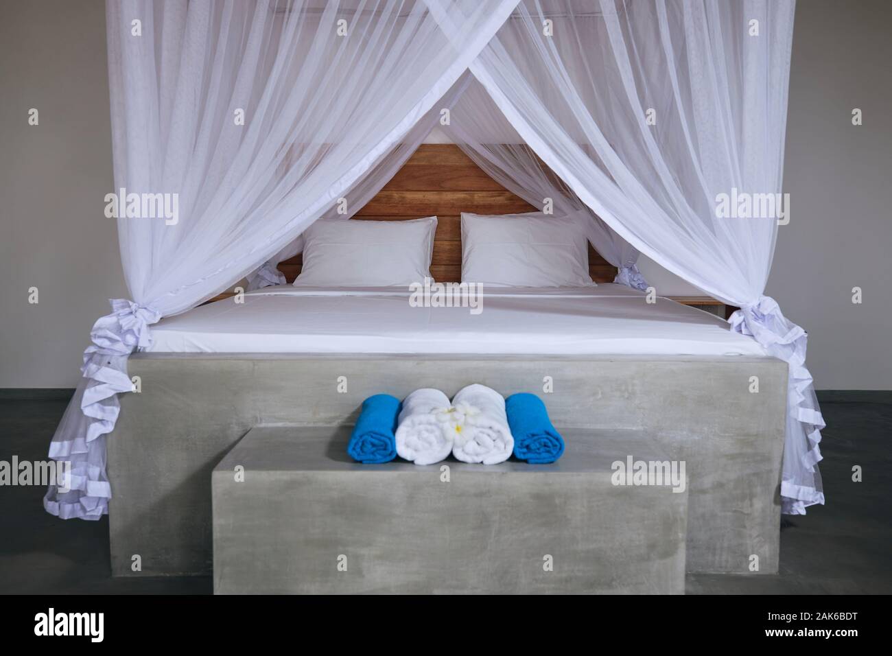Luxuriöse Unterkunft in tropischen Ziel. Doppelbett mit Moskitonetz in moderne Bungalow. Stockfoto