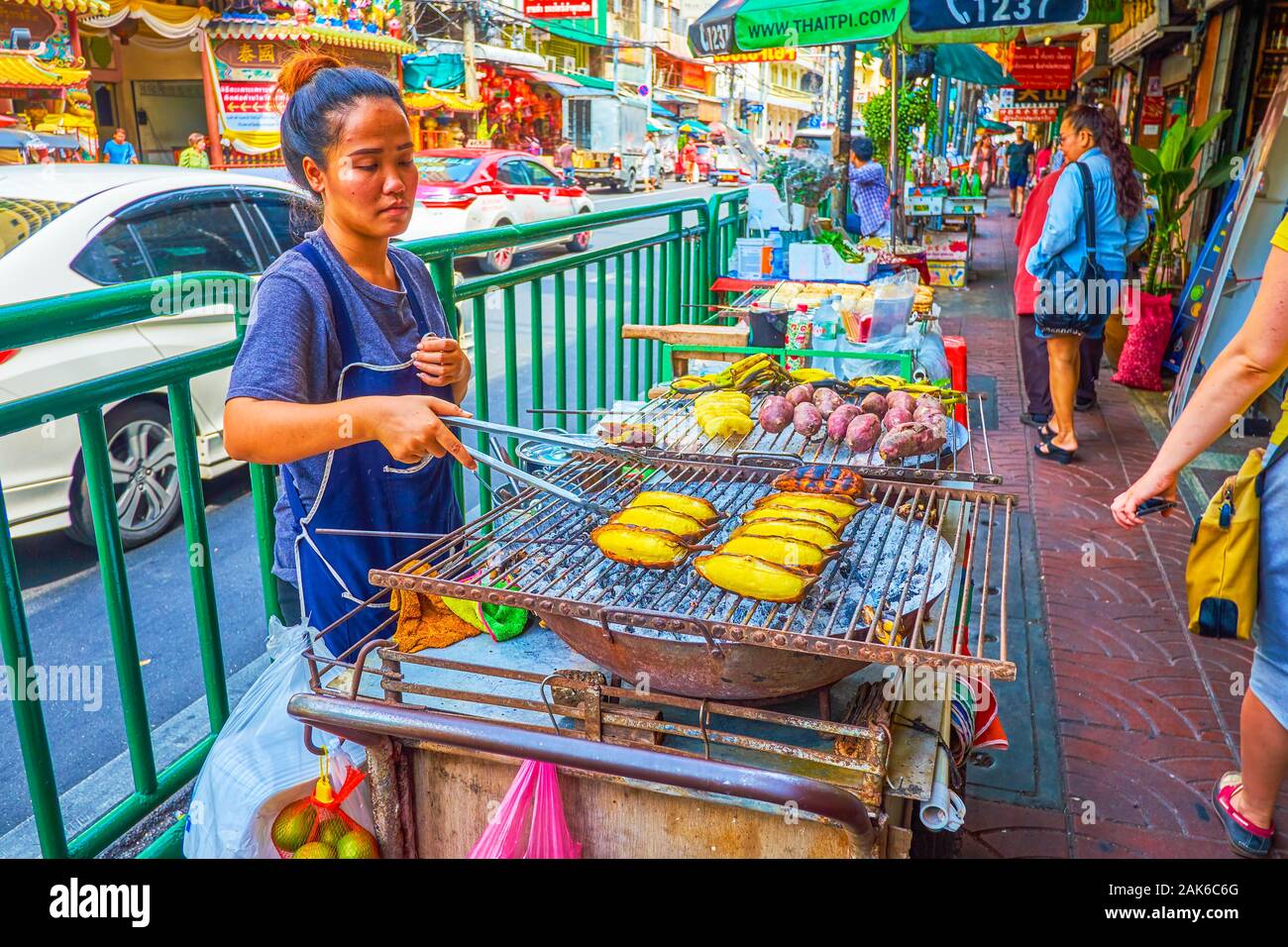 BANGKOK, THAILAND - 15 April, 2019: Der junge Koch bereitet frittierte Bananen und Süßkartoffeln auf der Straße in Chinatown, am 15. April in Bangkok. Stockfoto