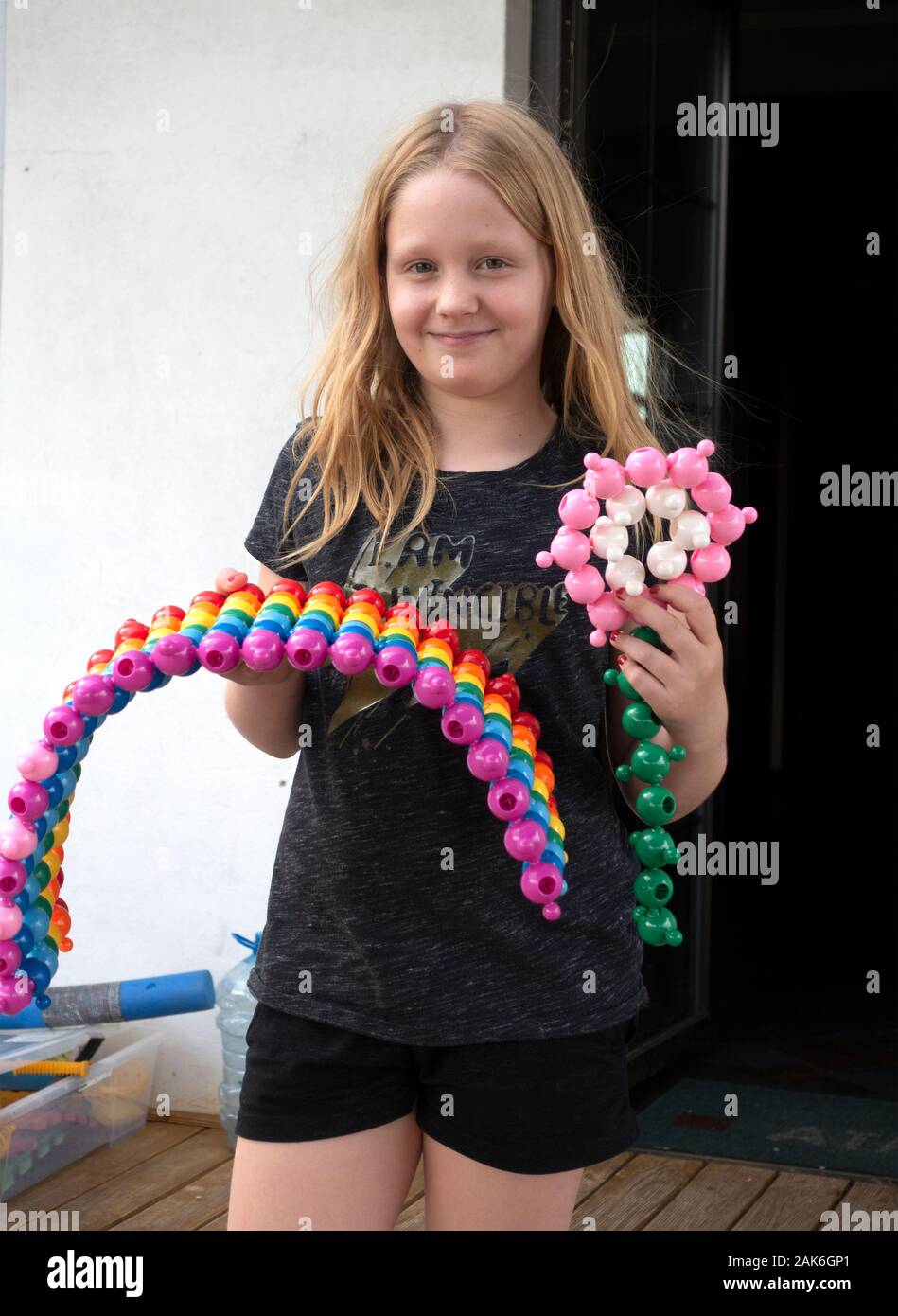 Mädchen, dass Regenbogen und Blume aus Loowi Magic Perlen zusammendrücken und Spielzeug. Zawady Gmina Rzeczyca Polen Stockfoto