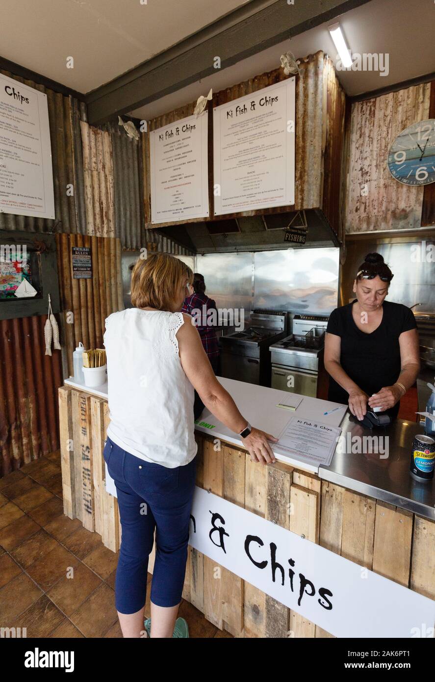 Kangaroo Island Australien; eine Touristin, die im KI Fish and Chip Shop, Kangaroo Island South Australia, Fisch und Pommes kauft Stockfoto