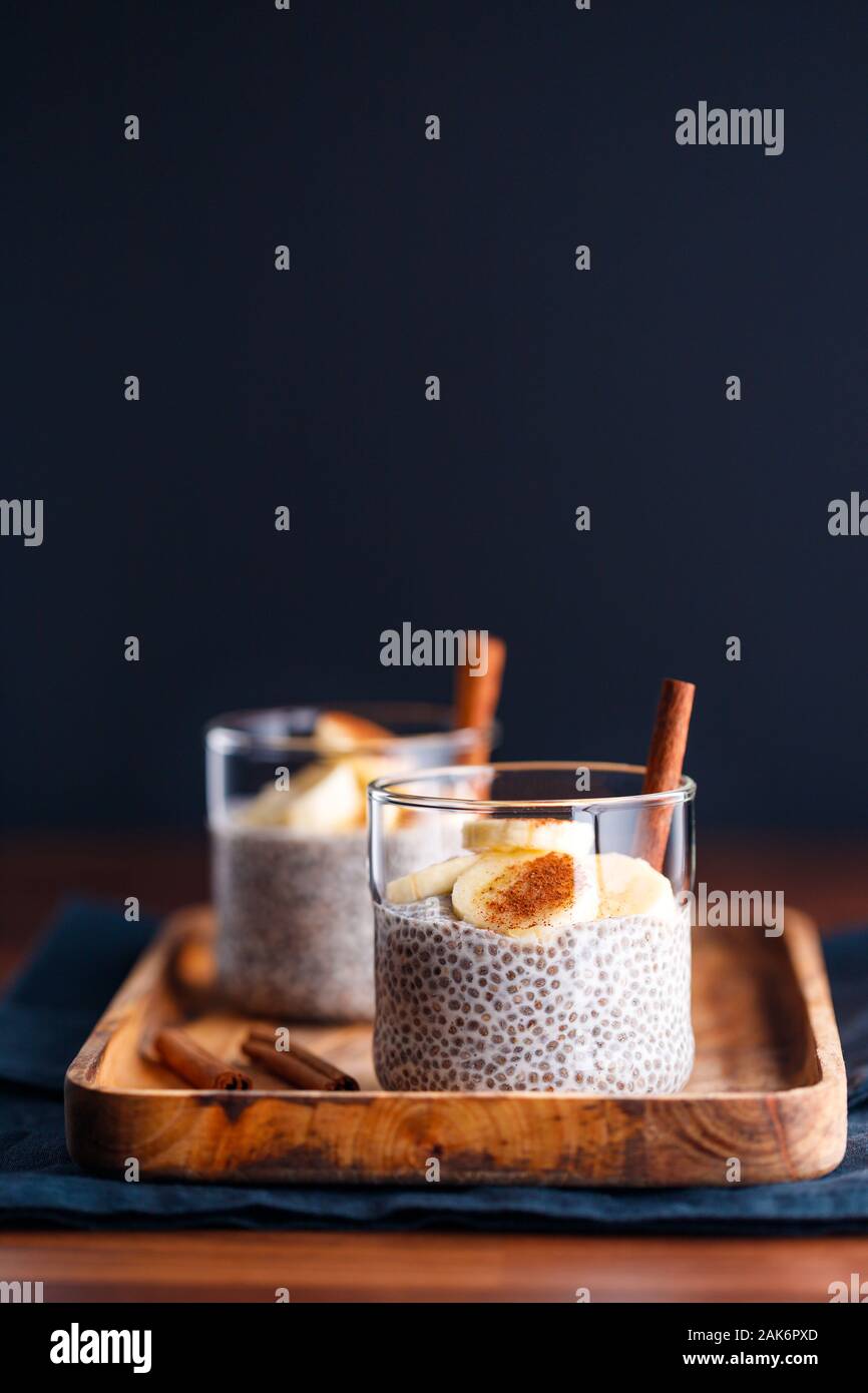 Chia Pudding mit Kokosmilch und Banane in Gläser auf einen Tisch. Vegetarische gesunde Dessert. Stockfoto