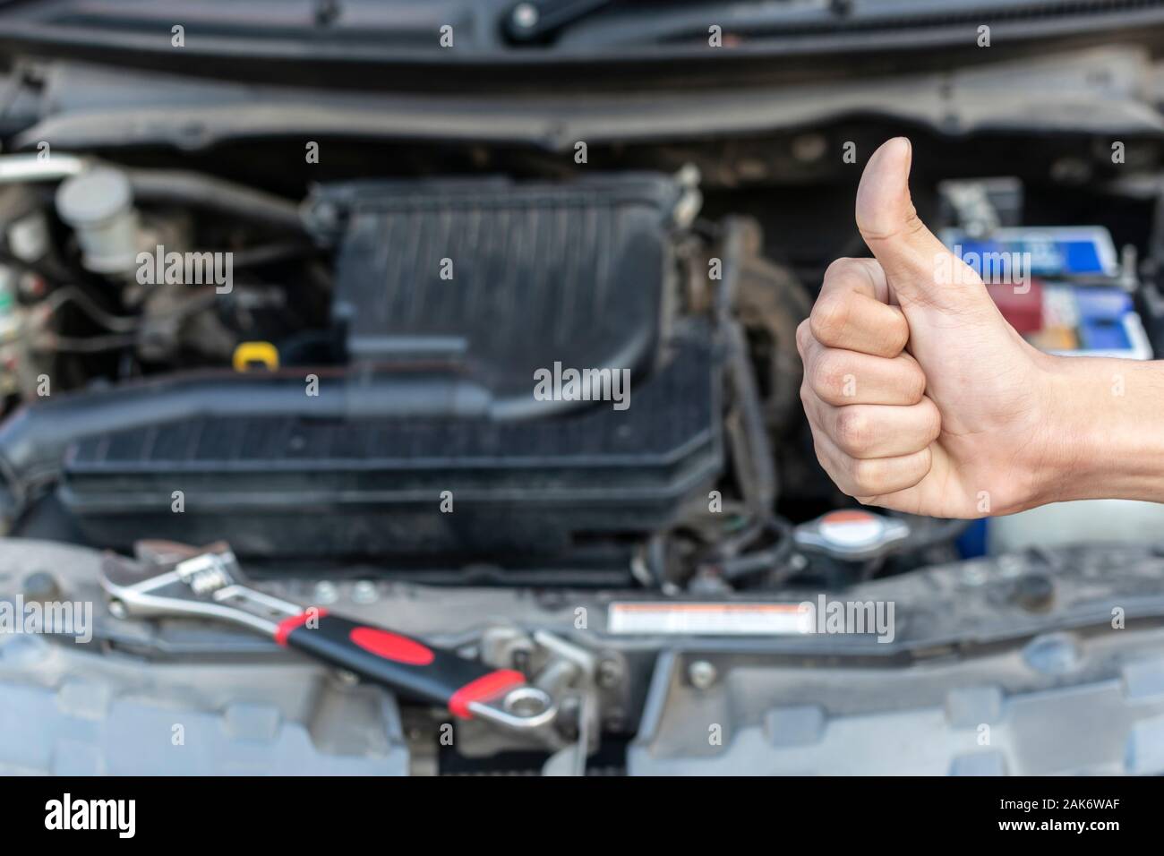 Automechaniker zeigen einen Daumen nach oben, nachdem das Auto, Überprüfung und Reparatur in der Werkstatt. Stockfoto